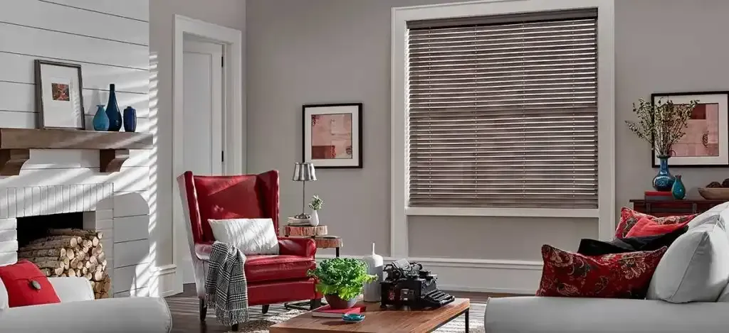 Living room with a red armchair, fireplace, and faux wood blinds