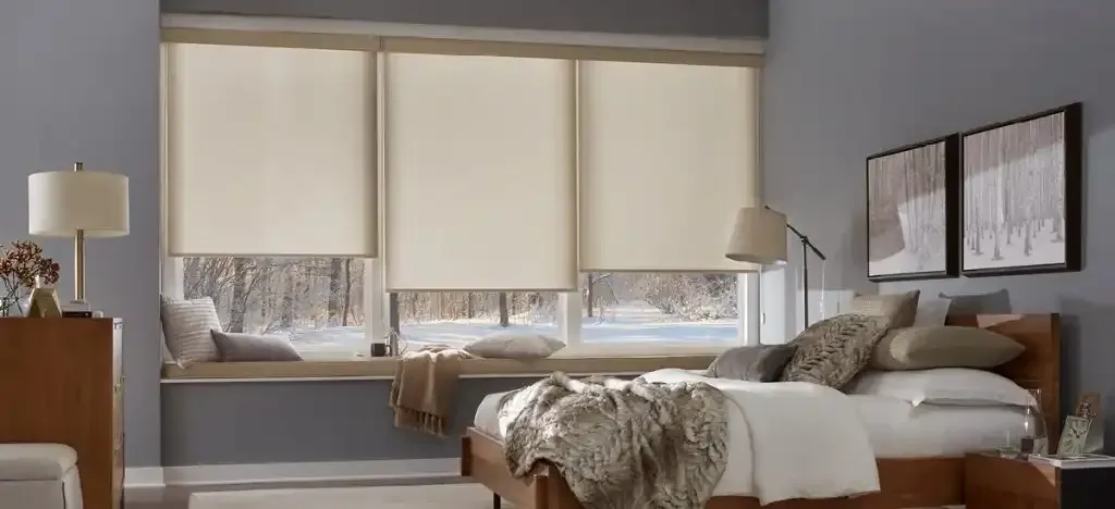 Bedroom with a bed, window seat, and neutral roller shades