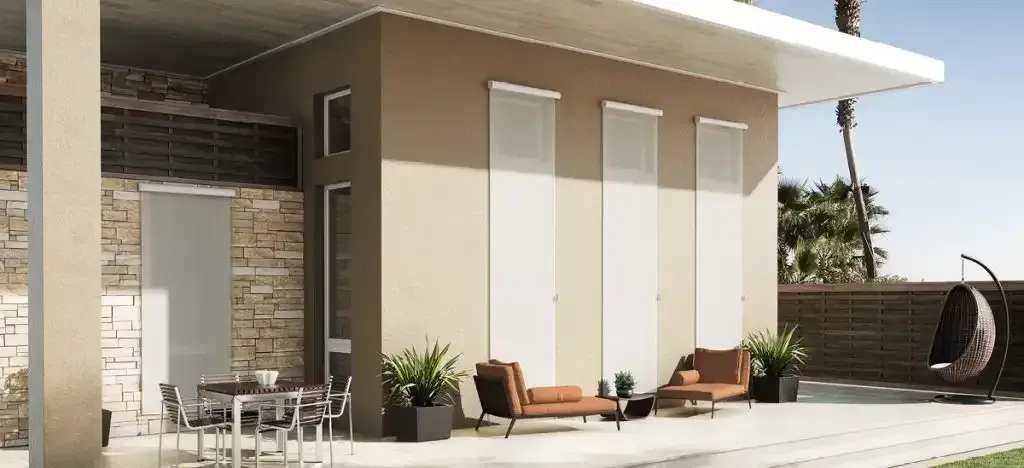 Modern outdoor patio with seating, plants, and a swing chair; house exterior with tan walls.